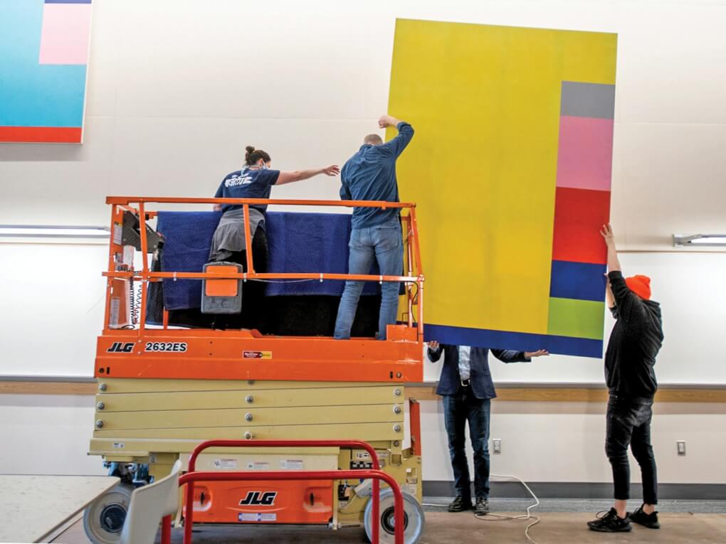 A crew installs the a colorful abstract art work